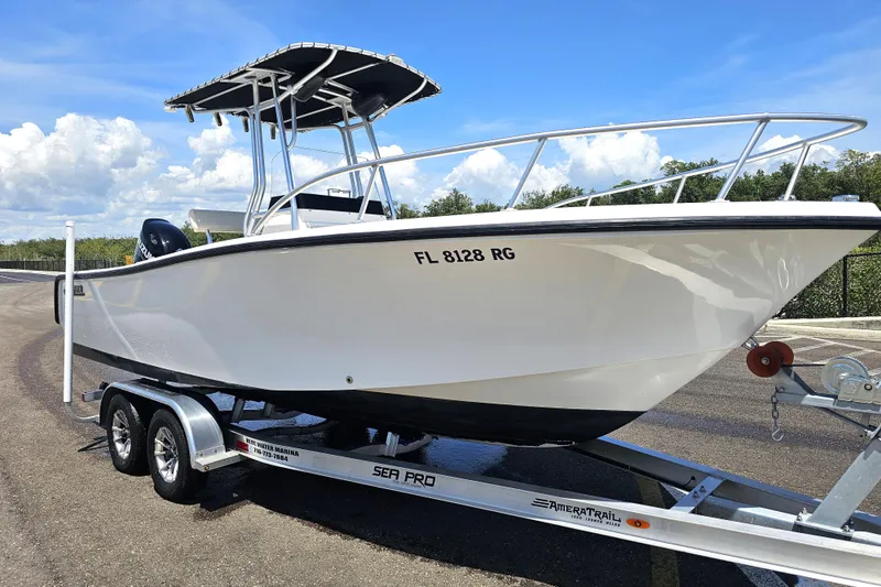 The Image of 2005 Mako 212 Center Console boat on trailer, parked outdoors under a blue sky. - 0