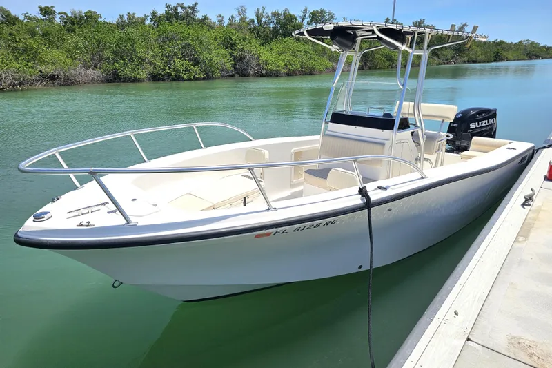 Slide: The Image of 2005 Mako 212 Center Console boat docked on a calm waterway. - 10