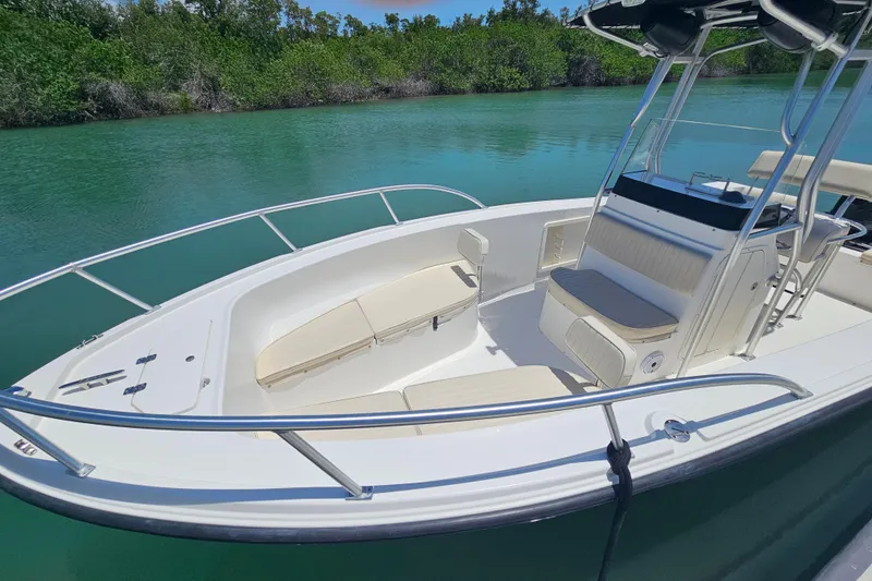 Slide: The Image of 2005 Mako 212 Center Console boat on calm water, featuring spacious seating and sleek design. - 11
