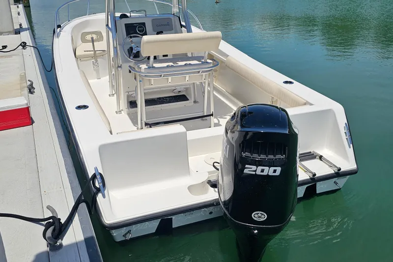 Slide: The Image of 2005 Mako 212 Center Console boat docked with powerful 200 HP outboard motor. - 13
