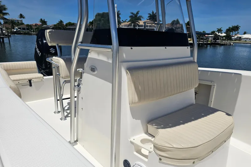 Slide: The Image of 2005 Mako 212 Center Console boat interior with seating, on a sunny waterfront. - 17