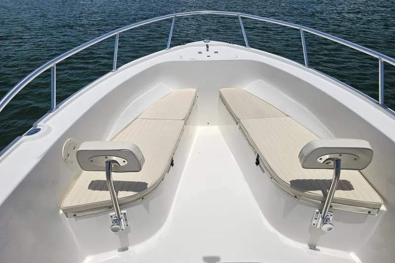 Slide: The Image of 2005 Mako 212 Center Console boat interior with cushioned seating, surrounded by calm water. - 24
