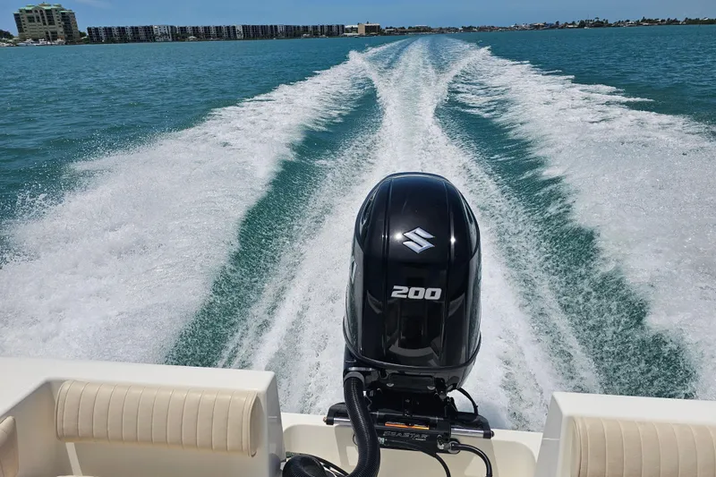 Slide: The Image of 2005 Mako 212 Center Console boat with Suzuki 200 engine cruising on open water. - 26