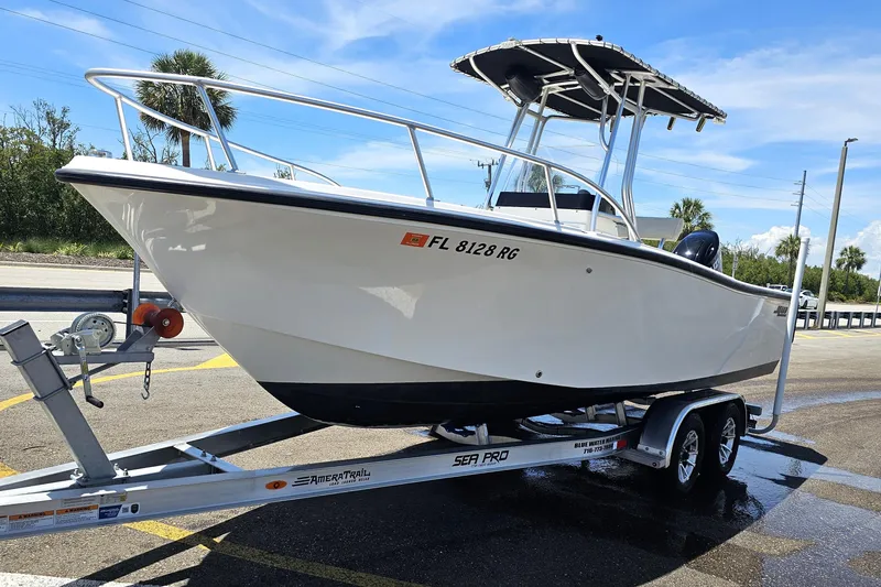 Slide: The Image of 2005 Mako 212 Center Console boat on trailer, parked outdoors under clear sky. - 3