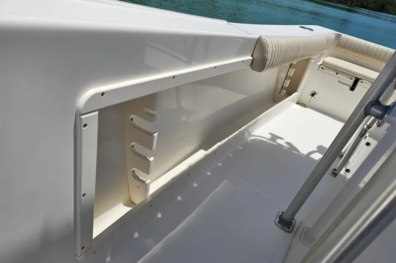 Slide: The Image of 2005 Mako 212 Center Console boat interior with rod holders and cushioned seating. - 33