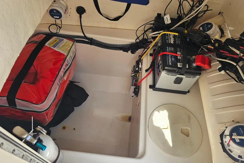 Slide: The Image of Storage compartment of a 2005 Mako 212 Center Console with battery and safety gear. - 40