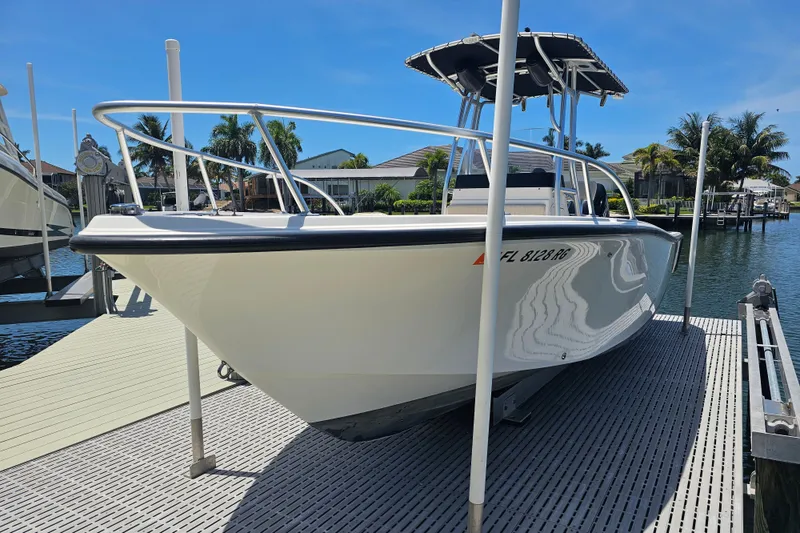 Slide: The Image of 2005 Mako 212 Center Console boat docked on a sunny day by the water. - 6