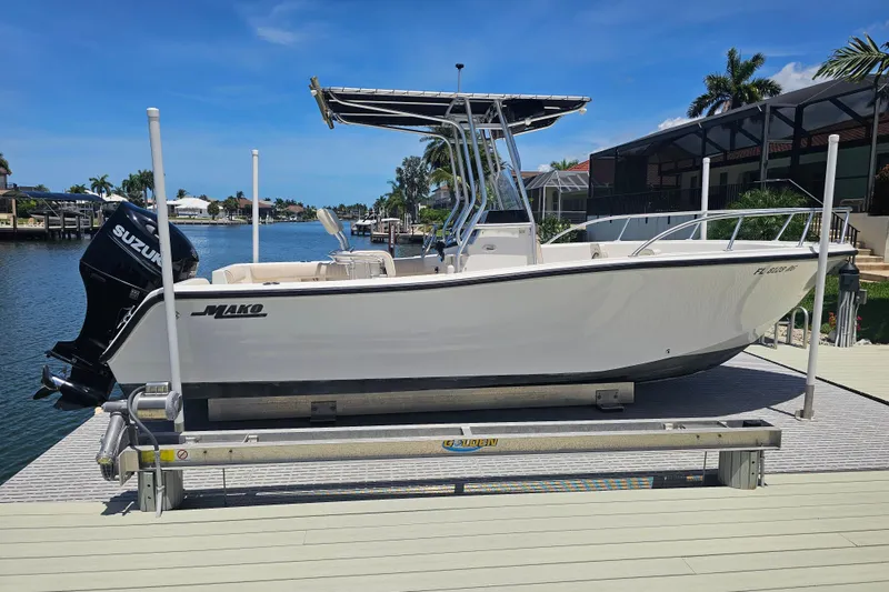 Slide: The Image of 2005 Mako 212 Center Console boat on a lift by a waterfront dock. - 8