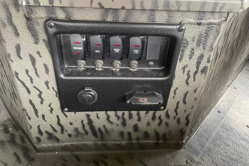 Slide: The Image of Control panel of 2026 War Eagle 750 Gladiator boat with switches and 12V outlet. - 15