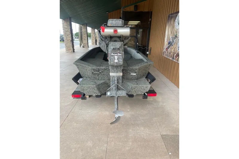 Slide: The Image of 2026 War Eagle 750 Gladiator boat with camouflage design, parked outside a building. - 9