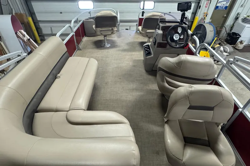 Slide: The Image of 2022 Sun Tracker Bass Buggy 18 DLX interior with beige seating and steering console. - 15