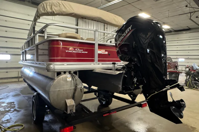 Slide: The Image of 2022 Sun Tracker Bass Buggy 18 DLX pontoon boat with Mercury outboard motor in a garage. - 4