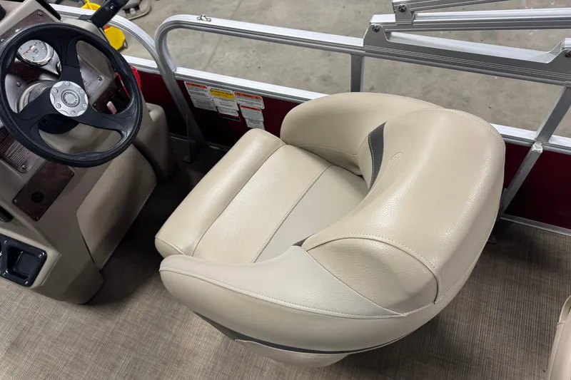 Slide: The Image of 2022 Sun Tracker Bass Buggy 18 DLX boat interior with steering wheel and beige captain's chair. - 8