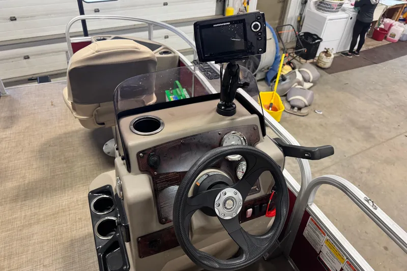 Slide: The Image of 2022 Sun Tracker Bass Buggy 18 DLX boat dashboard with steering wheel and navigation system. - 9