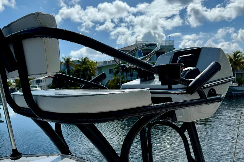 Slide: The Image of 2021 Pathfinder 2400 TRS boat helm with steering wheel, overlooking a scenic waterfront. - 10