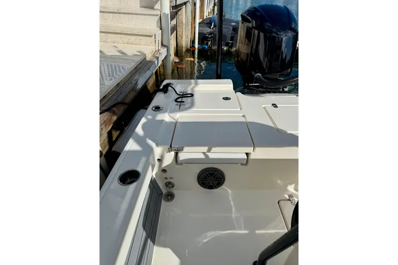 Slide: The Image of 2021 Pathfinder 2400 TRS boat docked, featuring a clean deck and powerful outboard motor. - 12