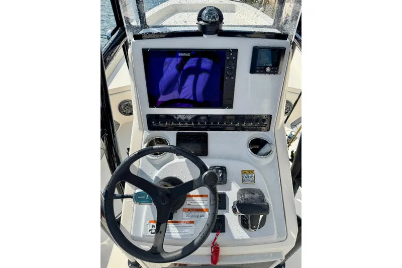 Slide: The Image of 2021 Pathfinder 2400 TRS boat console with steering wheel and navigation display. - 2