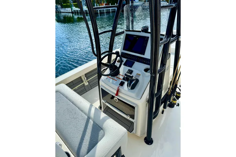 Slide: The Image of 2021 Pathfinder 2400 TRS boat console with steering wheel and controls by the water. - 4