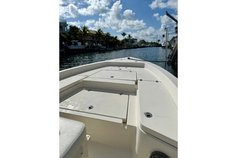 Slide: The Image of 2021 Pathfinder 2400 TRS boat on a sunny canal with palm trees and blue sky. - 7