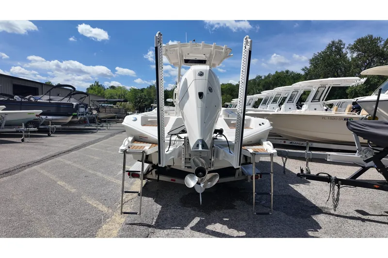 Slide: The Image of 2024 Ranger 2660 Bay boat on trailer, parked in marina under blue sky. - 16