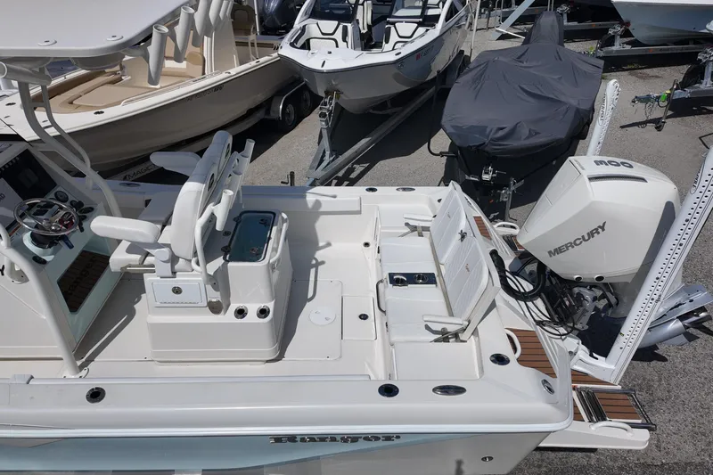 Slide: The Image of 2024 Ranger 2660 Bay boat with Mercury engine, docked alongside other boats. - 19