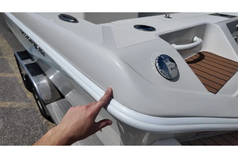 Slide: The Image of 2024 Ranger 2660 Bay boat detail with hand pointing at sleek design feature. - 20