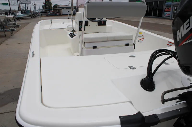 Slide: The Image of 2021 Mako Pro Skiff 17 CC boat with seating and outboard motor, displayed outdoors. - 11