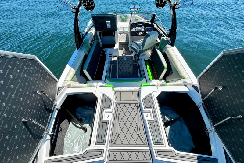 Slide: The Image of 2016 Tigé RZX3 boat interior with open storage compartments on a sunny day. - 26