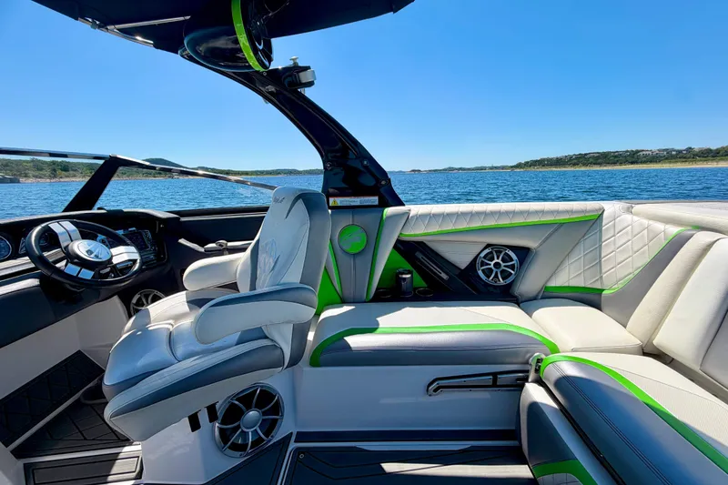 Slide: The Image of 2016 Tigé RZX3 boat interior with luxurious seating and modern dashboard on a sunny lake. - 29