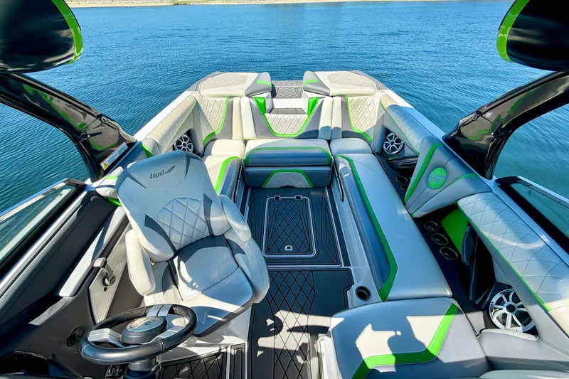 Slide: The Image of Interior of a 2016 Tigé RZX3 boat with stylish seating and steering wheel on a lake. - 30