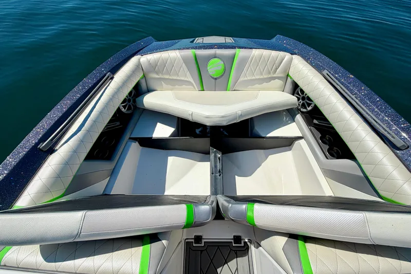 Slide: The Image of 2016 Tigé RZX3 boat interior with white and green seating on calm water. - 34