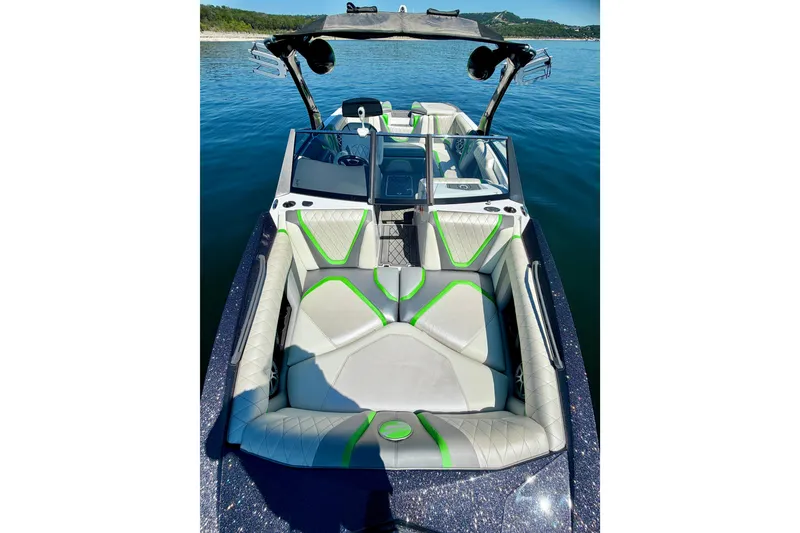 Slide: The Image of 2016 Tigé RZX3 boat interior with green accents on a calm lake. - 36
