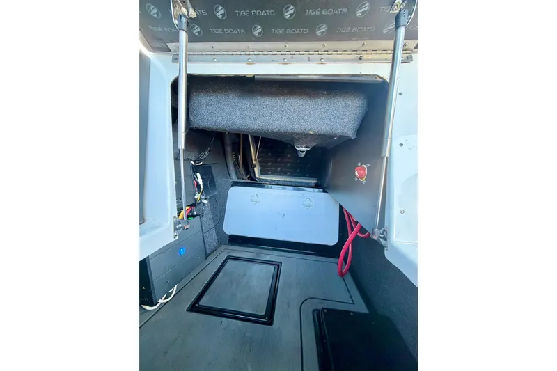 Slide: The Image of Interior view of a 2016 Tigé RZX3 boat compartment with storage and wiring. - 38
