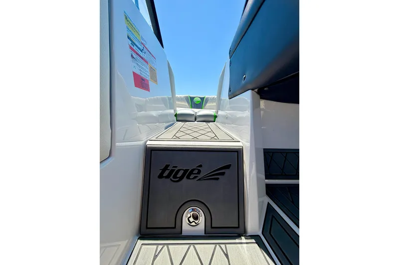 Slide: The Image of 2016 Tigé RZX3 boat interior with branded flooring and seating, under clear blue sky. - 41
