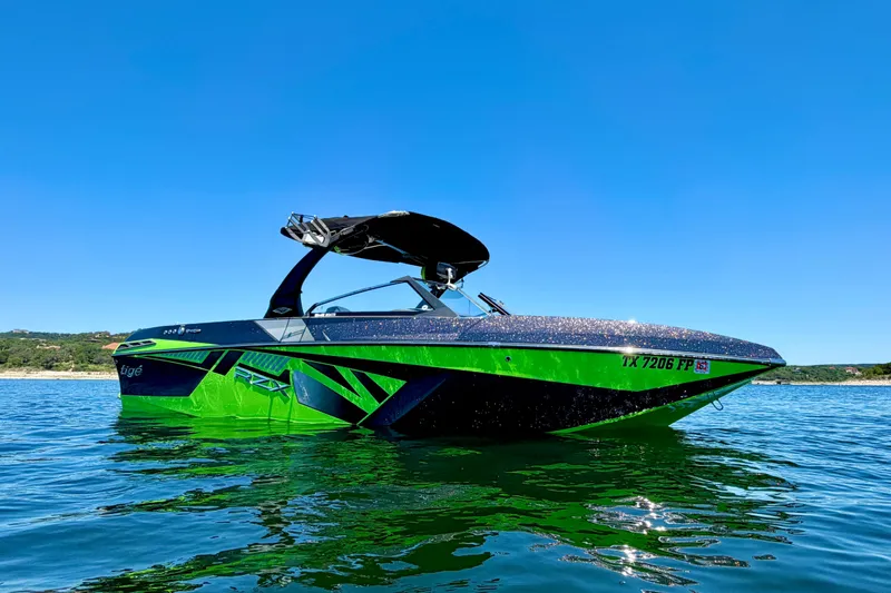Slide: The Image of 2016 Tigé RZX3 boat on water, vibrant green and black design, clear blue sky background. - 5