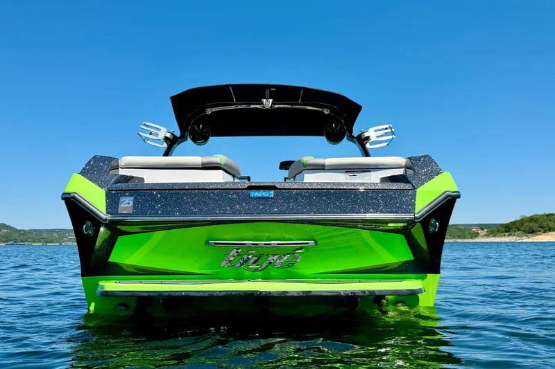 Slide: The Image of 2016 Tigé RZX3 boat on water, vibrant green and black design, sunny day. - 7