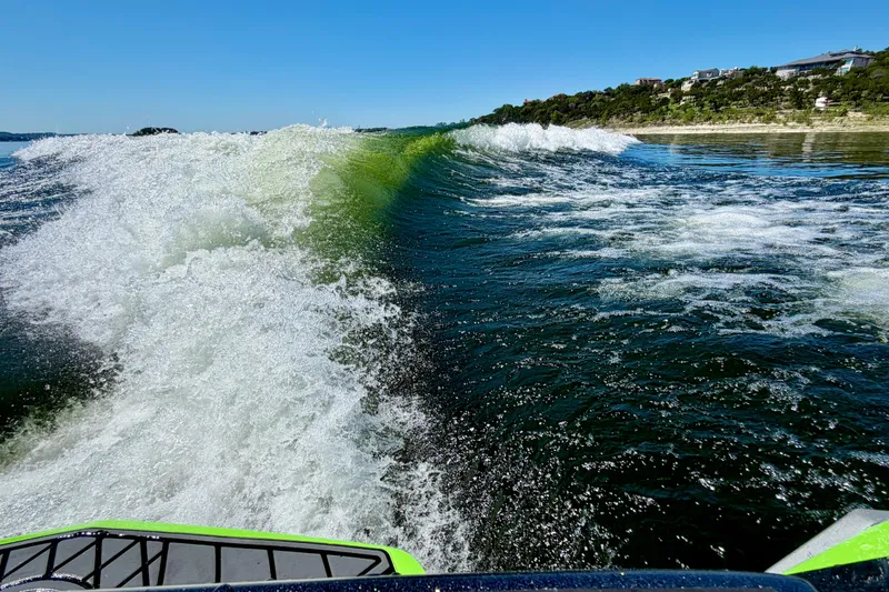 Slide: The Image of Waves created by a 2016 Tigé RZX3 boat on a sunny lake. - 8