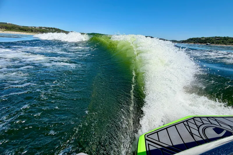 Slide: The Image of Wake surfing behind a 2016 Tigé RZX3 boat on a sunny day. - 9