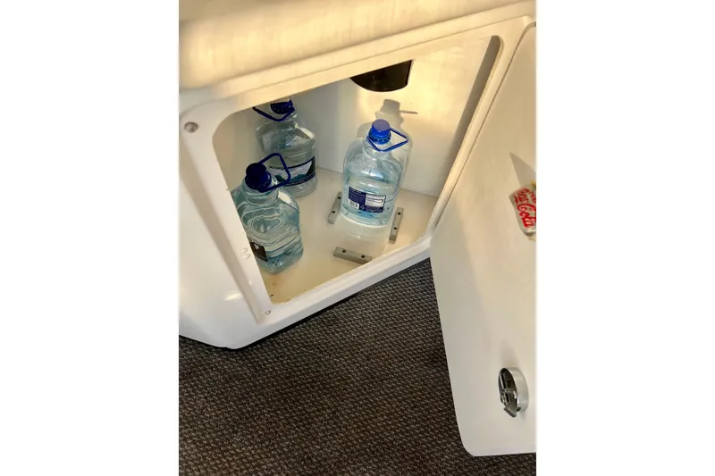 Slide: The Image of Storage compartment with water jugs inside a 1997 Sea Ray 370 Aft Cabin boat. - 16