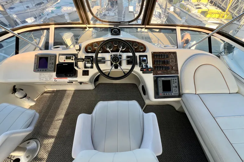 Slide: The Image of 1997 Sea Ray 370 Aft Cabin helm with modern navigation equipment and comfortable seating. - 23