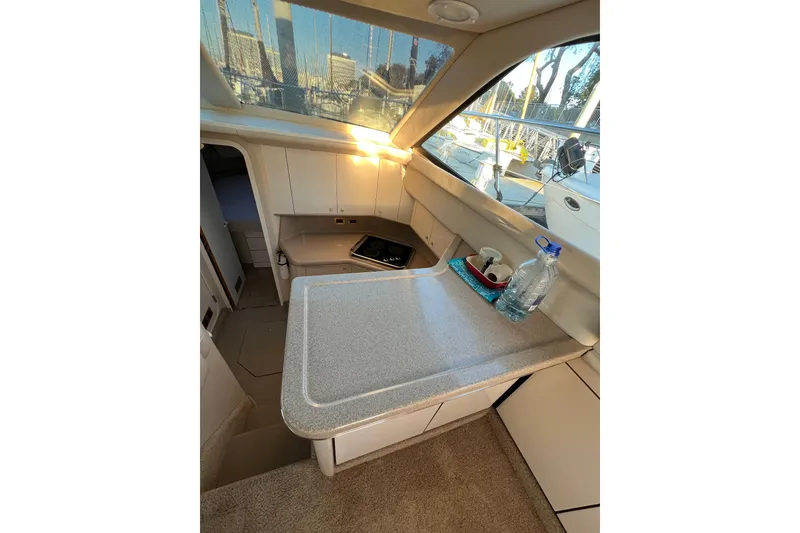 Slide: The Image of 1997 Sea Ray 370 Aft Cabin interior with countertop, cabinets, and window view. - 34