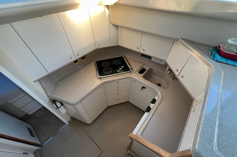 Slide: The Image of 1997 Sea Ray 370 Aft Cabin kitchen with stove, sink, and ample storage. - 36