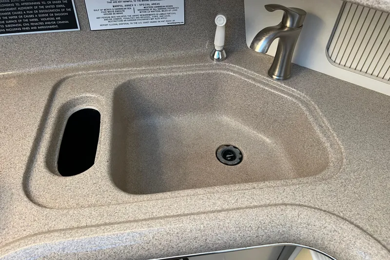 Slide: The Image of 1997 Sea Ray 370 Aft Cabin kitchen sink with modern faucet and beige countertop. - 40