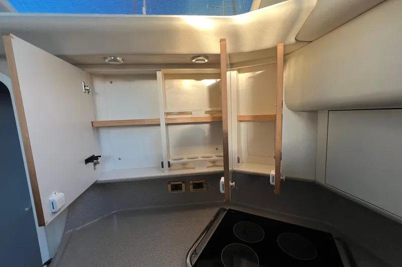Slide: The Image of 1997 Sea Ray 370 Aft Cabin kitchen with open cabinets and electric stove. - 42