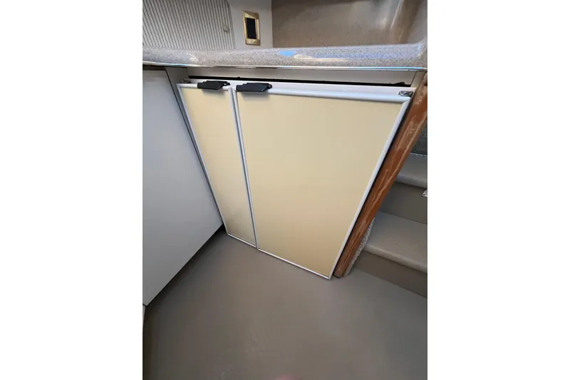 Slide: The Image of 1997 Sea Ray 370 Aft Cabin kitchen with beige cabinetry and countertop. - 44