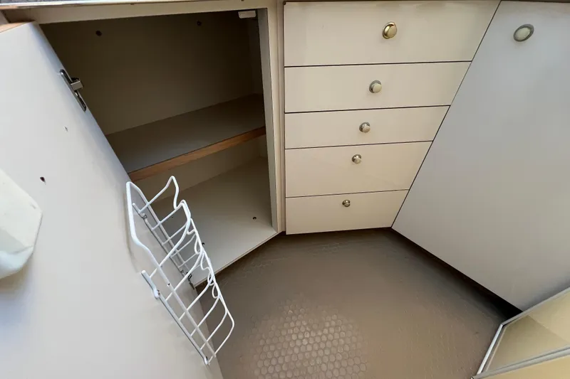 Slide: The Image of 1997 Sea Ray 370 Aft Cabin interior storage with open cabinet and drawers. - 46