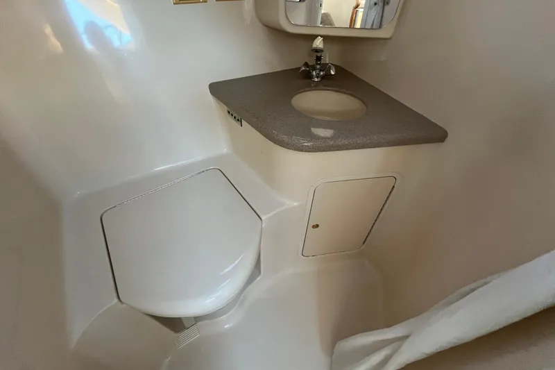 Slide: The Image of 1997 Sea Ray 370 Aft Cabin bathroom with toilet, sink, and storage cabinet. - 55