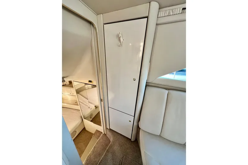 Slide: The Image of Interior of 1997 Sea Ray 370 Aft Cabin, featuring white cabinetry and seating. - 58