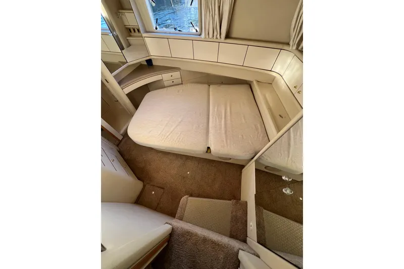 Slide: The Image of 1997 Sea Ray 370 Aft Cabin interior with bed, carpet, and storage cabinets. - 64