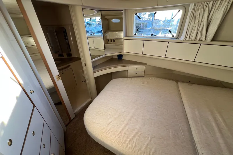 Slide: The Image of 1997 Sea Ray 370 Aft Cabin interior with bed, storage, and window view. - 65